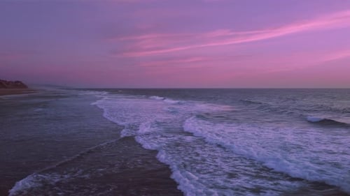 Sea shore with waves. Pink sky at sunset or sunrise. Cinematic shot. Oregon. Pacific Ocean