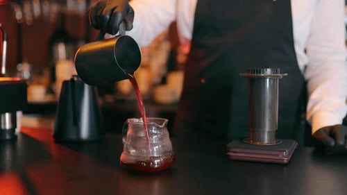 A Barista Pours Coffee Into a Glass Pouring Black Filtered Coffee Into a Glass Close Up Slow Motion