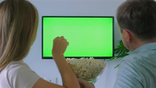 Couple Relaxing and Watching TV with Green Screen in Living Room