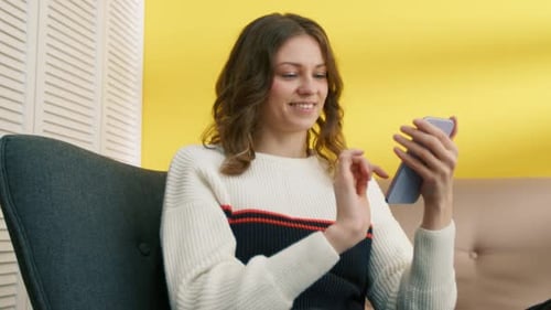 Woman Using Mobile Phone While Sitting in Chair