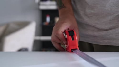 Man measuring table with tape measure