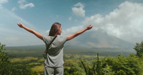 Woman Standing on Lush Green Hillside