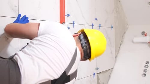 Man Installing Tile in Bathroom