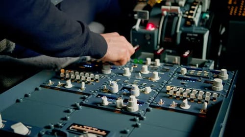 The captain presses the buttons on the control panel to start the engine of the plane flight Up