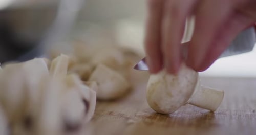 Mushrooms Being Sliced on a Wooden Board