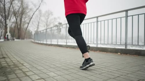 Legs and Feet Jogging on Paved Path