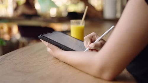Close Up of Woman Using Stylus on Tablet