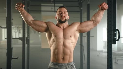 Muscular Man Flexing Biceps in a Gym