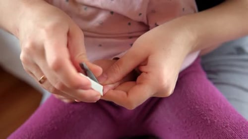 Adult Clips Child's Nails at Home