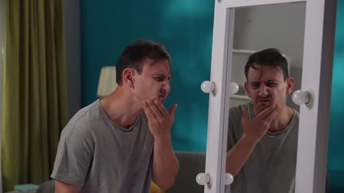 An Exhausted Tired Man Suffering From a Mental Disorder Looks at His Reflection in a Large Mirror