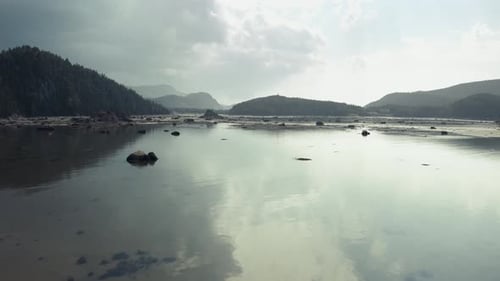 Incoming epic storm landscape. Drone move forward. Slow and low over low tide ocean bay. Storm and s