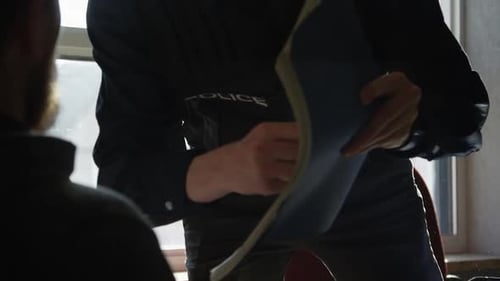 Police Officer with File Confronts a Man