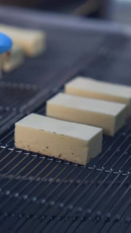 Milky bars of sweets being put on the moving conveyor line.