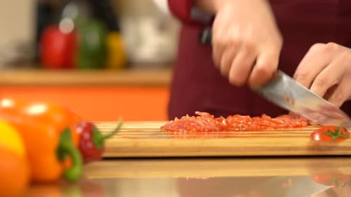 Chef fast chopping red tomato. Man' s hand fast cutting tomato, close view.