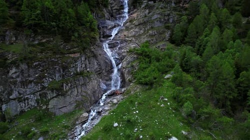 Aerial View of Waterfall Cascading Down Rocky Cliff