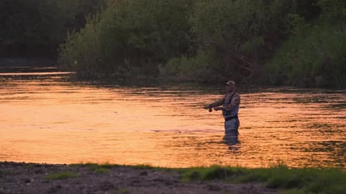 Fly fishing. Fisherman casts fly on the river at sunset. Caucasian amateur angler fishing on the riv