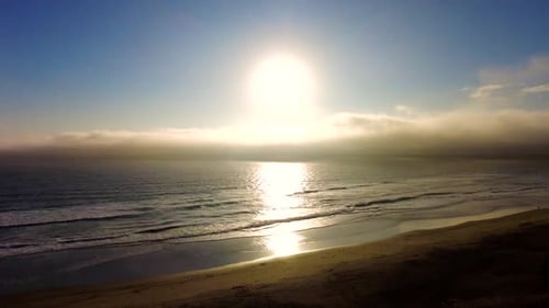 Sun setting over Blue ocean waves in the evening