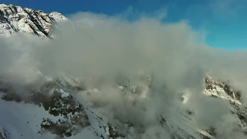 Majestic Snowy Mountains Shrouded in Clouds Aerial View