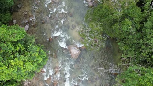 Harmony of water flowing over textured river rocks.