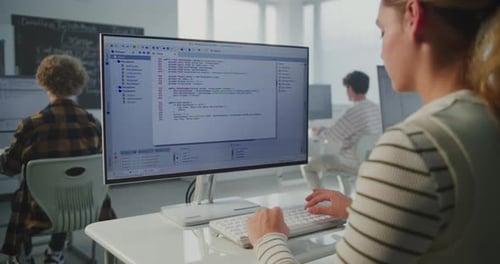 In Game Dev Workshop Young Woman Typing Program Code on Monitor