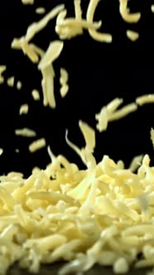 Shredded Cheese Falling on Black Background Filmed on a Highspeed Camera at 1000 Fps