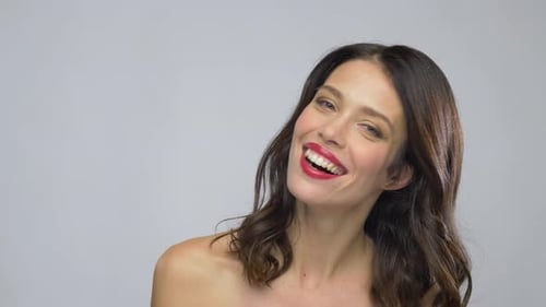 Smiling woman with red lipstick in studio setting