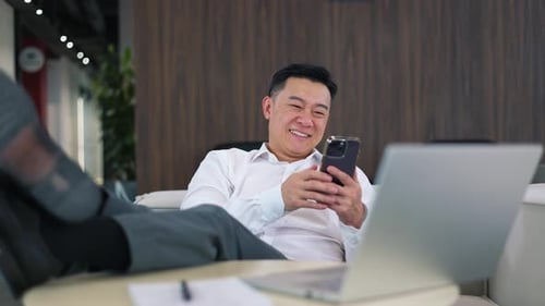 Smiling Office Worker Using Modern Smartphone While Resting After Work