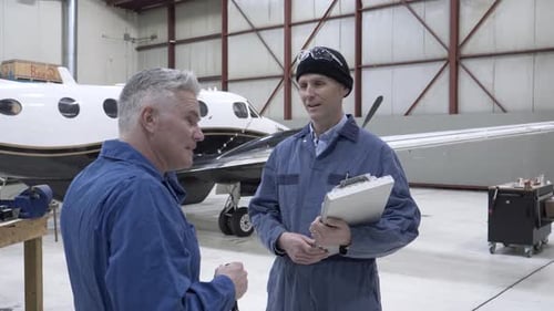 Mecánico masculino hablando en un hangar de aviones para adultos