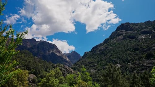 Timelapse of traveling clouds on top of the mountain summit. Vibrant blue sky.