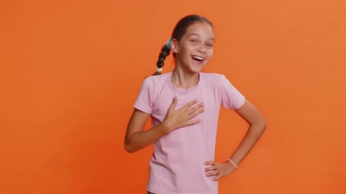 Happy Girl Laughing and Pointing on Orange Background