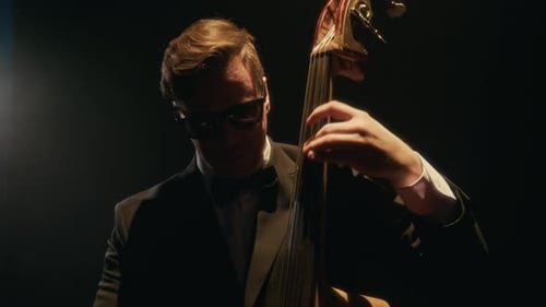 Musician Plays Upright Bass in Dark Spotlight