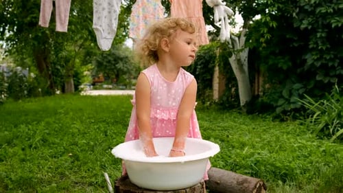 The Child is Washing Clothes in the Garden Selective Focus