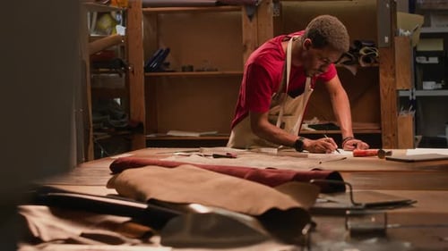 Dedicated Black Artisan Designing in Leather Workshop