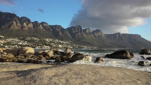 Low Altitude Flying Over Rock at Cape Town's Camps Bay Beach with Table Mountain in the Background a