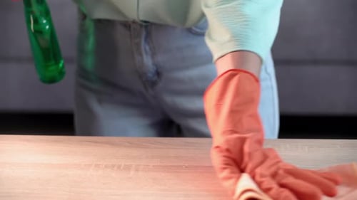Adult Cleaning Wooden Surface in Home