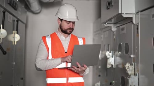 Electrical Engineer with Laptop Inspecting Industrial Equipment