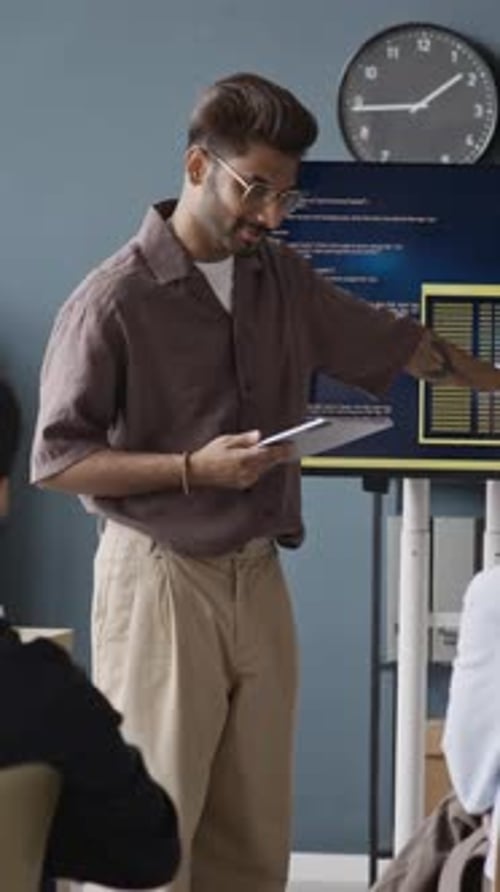 Vertical of Indian Businessman Explaining Programming Code during IT Meeting