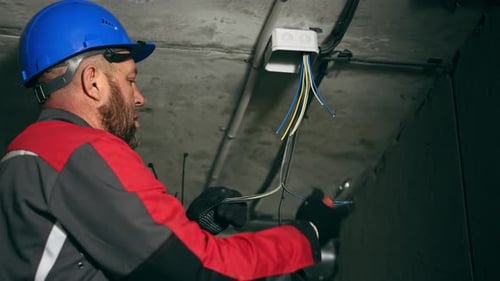 Electrician Wiring a Conduit in Building Wearing Hardhat