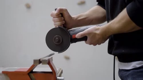 Young man working metal with tools