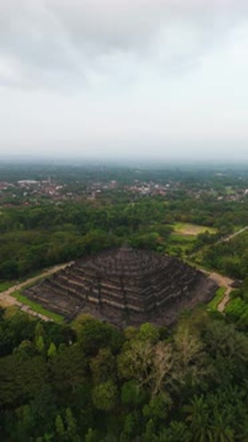 Borobudur-Tempel bei Sonnenuntergang mit üppiger Umgebung (Vertikal)