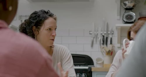 Friends Talking Together at Kitchen Table Indoors