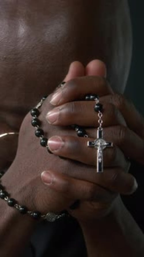 Close-up of Pastor Praying with Lowered Head, Closed Eyes and Hands Clasped