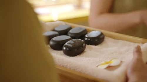 Balinese Spa Wellness Center Masseuse Takes Hot Pebble Stones for Massage From Tray Towel with