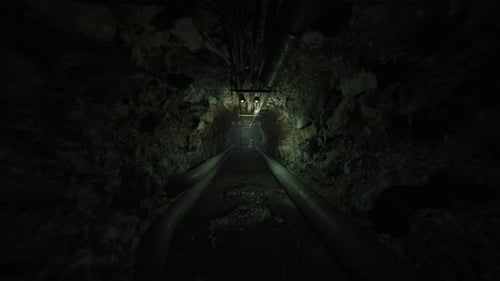 Enclosed Mossy Passage with Pipelines and Faint Glow in Distance