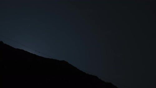 The full moon rising behind mountain ridge with beautiful glowing light