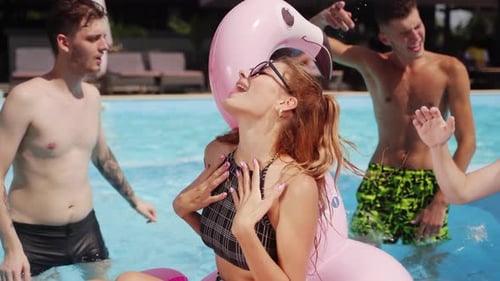 Woman Model in Sunglasses and Bikini Swimming in Inflatable Flamingo Tube on Summer Pool Party with