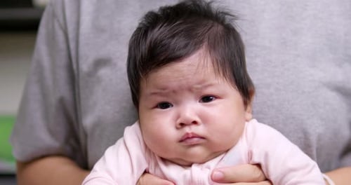 Adorable Infant Looking Around While Being Held