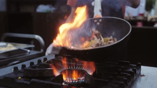 Chef Cooking with Wok and Flames