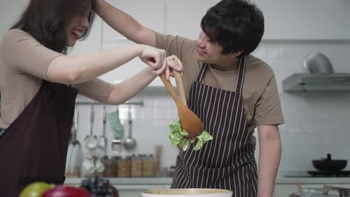 Couple Making Salad Together in a Bright Kitchen