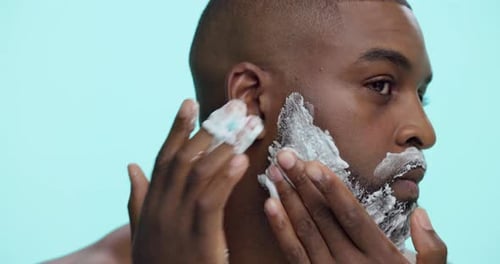 Studio, shaving and man with foam, beard and routine for hygiene in morning and facial treatment